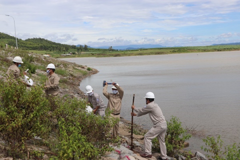 Xử lý tình huống sạt lở mái đập thượng lưu bằng rọ đá, bao cát gia cố và đóng cọc tre. Ảnh: Ngọc Minh